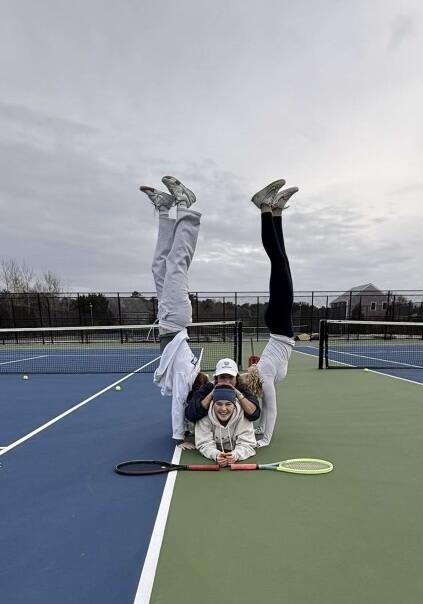 An Angel Warrior doing a handstand on a tennis court