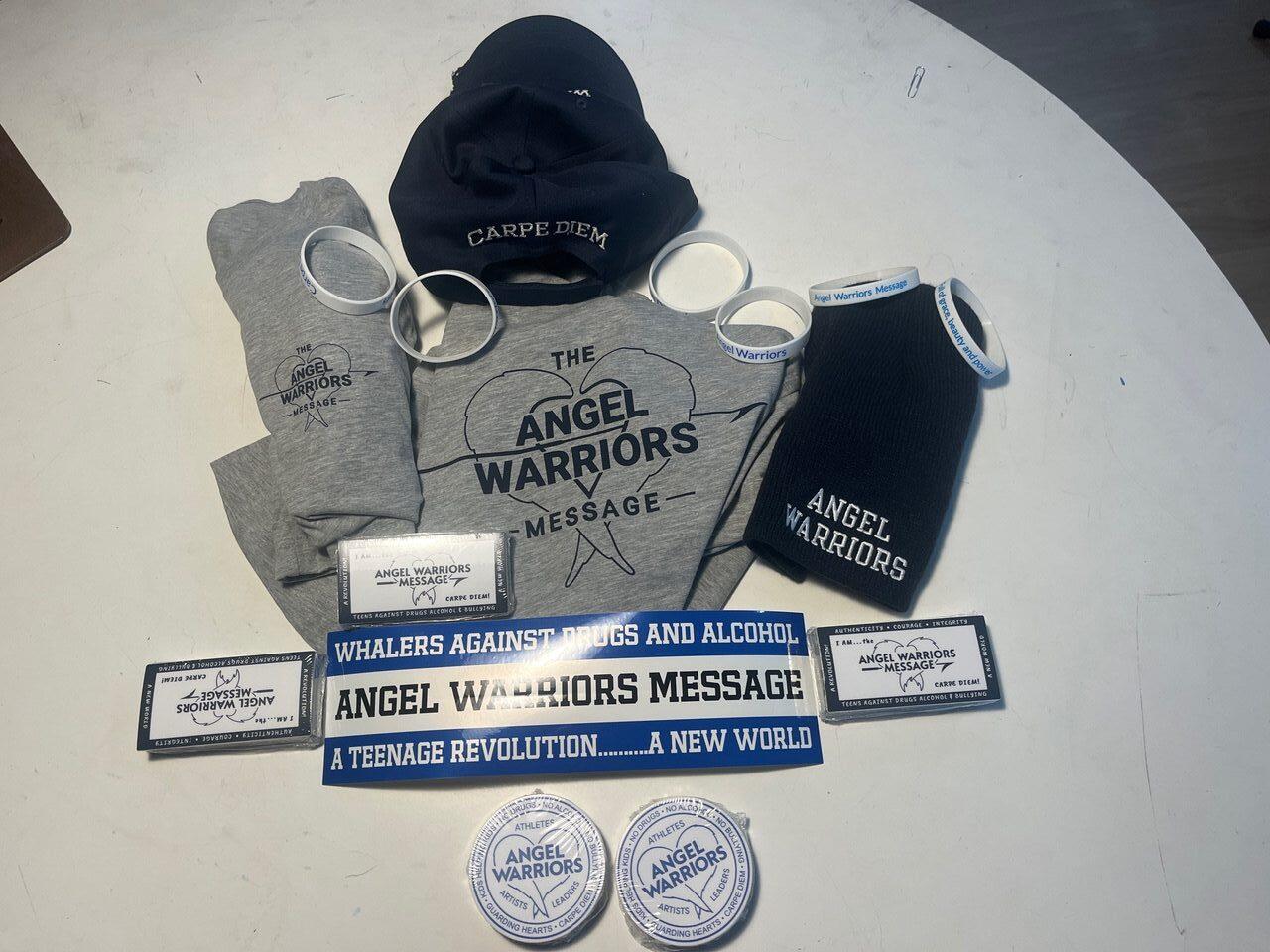 Angel Warriors kit laid out — a cap, a hoodie, socks, stickers and pins reading “A teenage revolution… a new world”