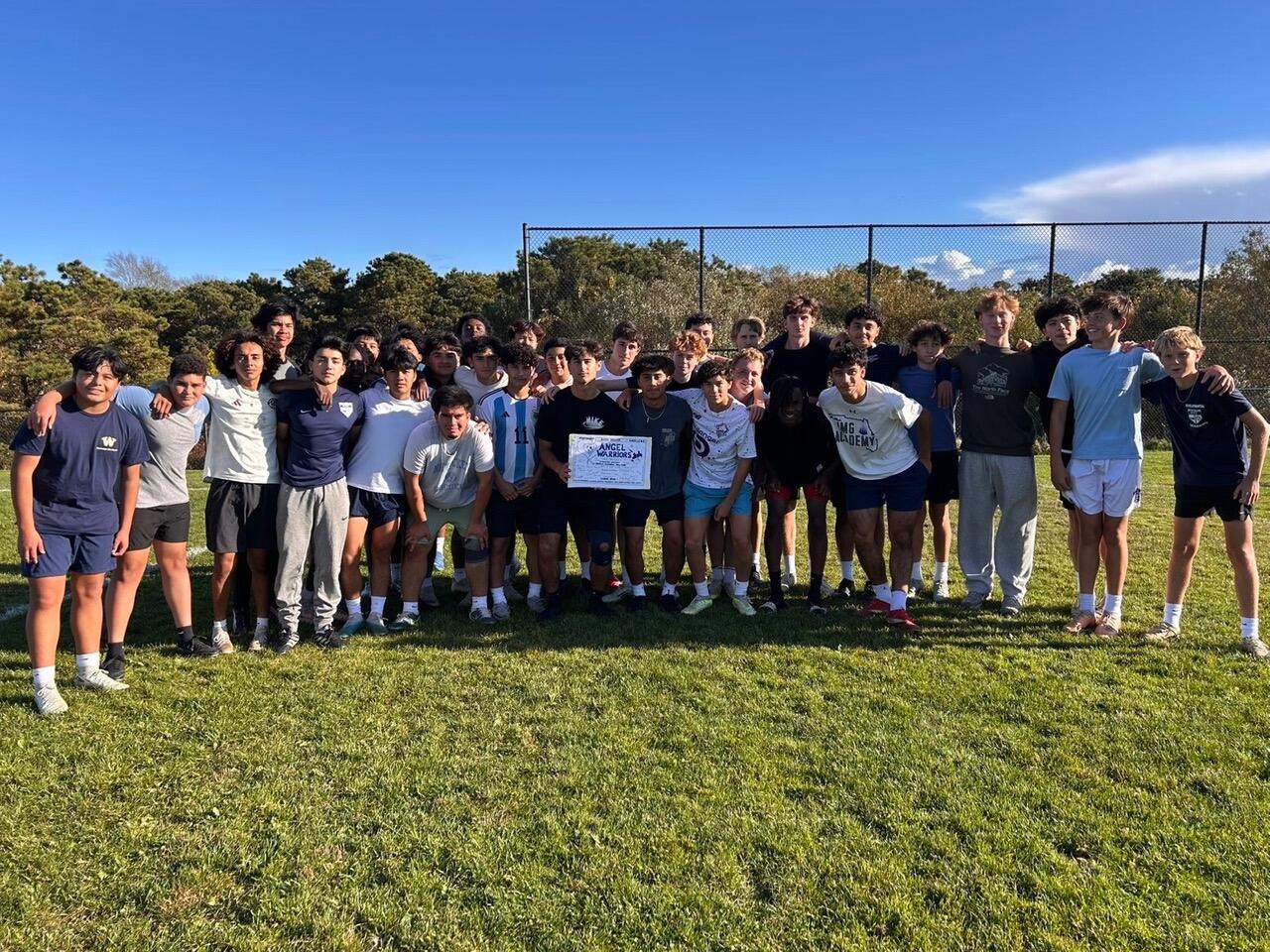 A large group of teenagers gathered on a playing field